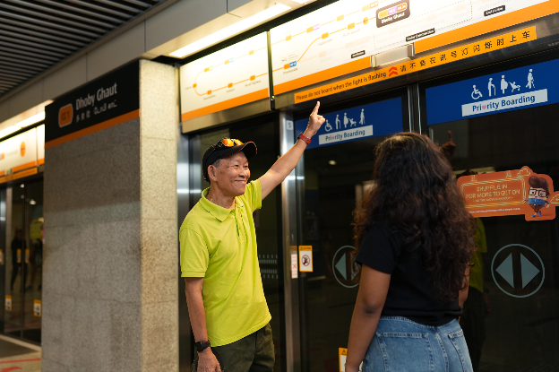 Photo of Michael guiding a commuter with directions at Dhoby Ghaut’s Circle Line Platform.